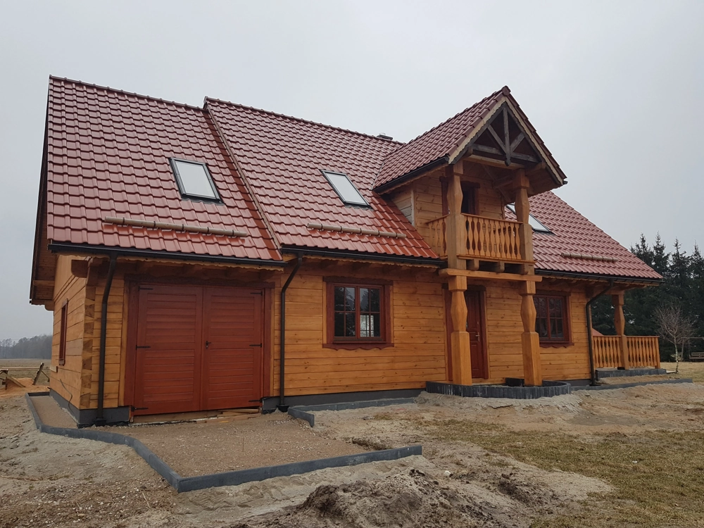 Dwukondygnacyjny dom z bali z garażem i czerwoną dachówką