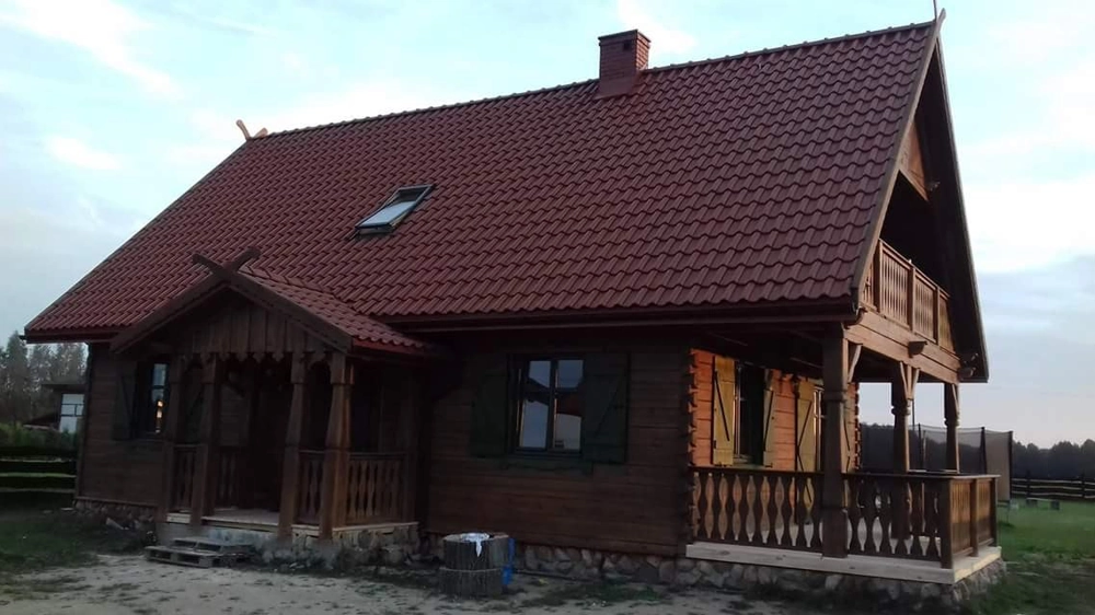 Domy z bali drewniany dom z bali na kamiennym fundamencie z podcieniem i balkonem